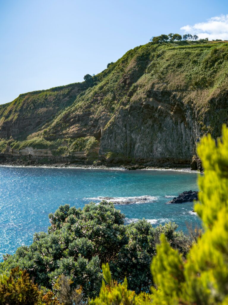 Cliffs and lush greenery overlooking the turquoise waters of the Azores coastline in Portugal